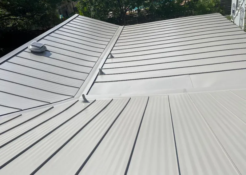 Solar attic fan installed on a metal roof for Roof Ventilation in Green